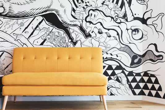 a yellow couch sitting in front of a wall with a mural on it